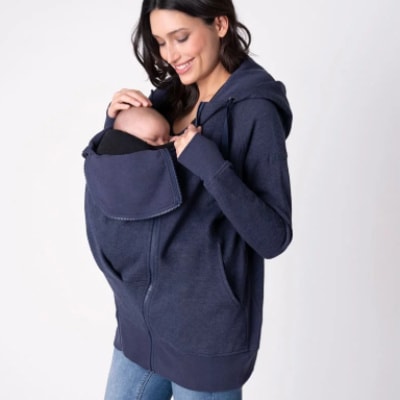 A woman carrying a baby on a 3-in-1 Maternity Hoodie