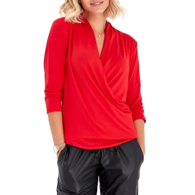 A woman wearing a red maternity/nursing blouse and black pants