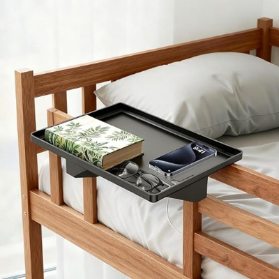 A bedside shelf with items on it, attached to the top bunk of a bunk bed