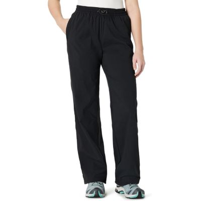 A woman wearing black pants, white top, and multicolored sneakers