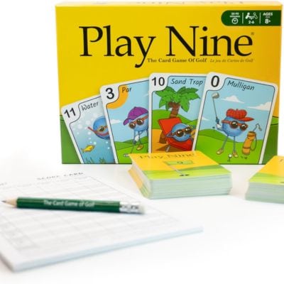 A yellow box for the card game Play Nine, next to a white scoring pad, two green golf pencils, and two stacks of cards