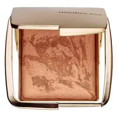 An open, gold-colored compact containing bronzer