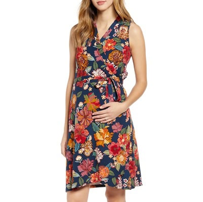 A woman wearing a colorful floral maternity wrap dress