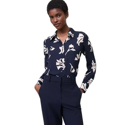 A woman wearing a navy floral button-front shirt and navy pants