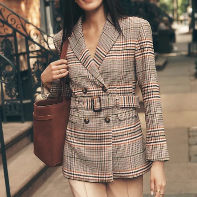 A woman wearing a pleated belted blazer
