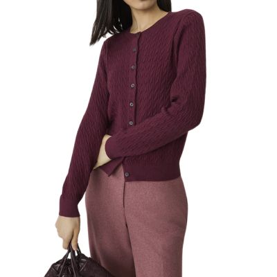 A woman wearing a wine-red cardigan with pink pants