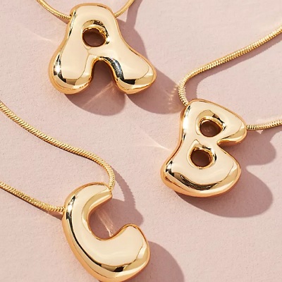 Three monogram pendants on chains -- A, B, and C