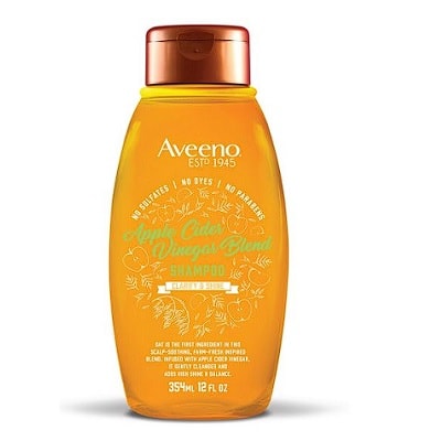 An orange bottle of Aveeno Apple Cider Vinegar Shampoo