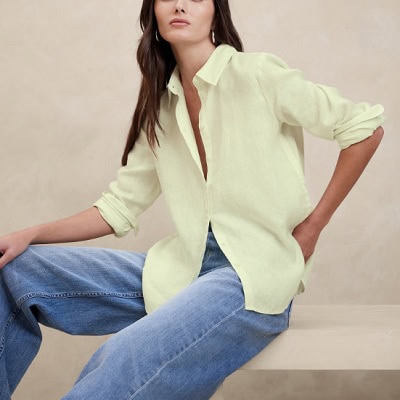 A woman wearing a pale yellow blouse and blue jeans