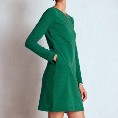 A woman wearing a green longs sleeve dress