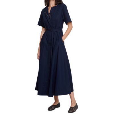 A woman wearing a black shirtdress and black flats