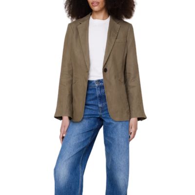 A woman wearing a white top, blue jeans, and a dark olive blazer