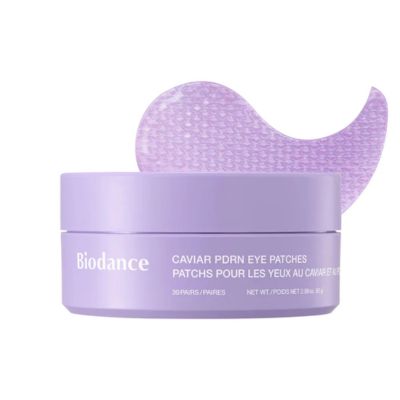 A purple container for an eye mask next to one purple eye mask