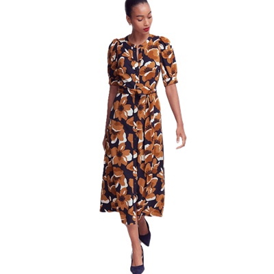 A woman wearing a navy, brown, and white floral dress and black heels