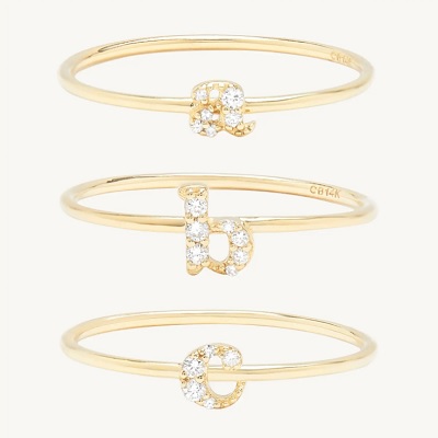 Three gold-and-diamond initial rings, A, B, and C