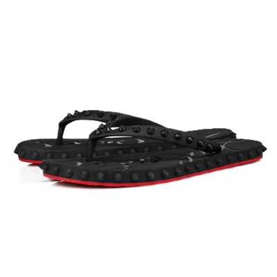 A black spiky flip flop with red sole