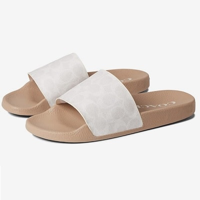 A pair of tan Coach slides with white tops