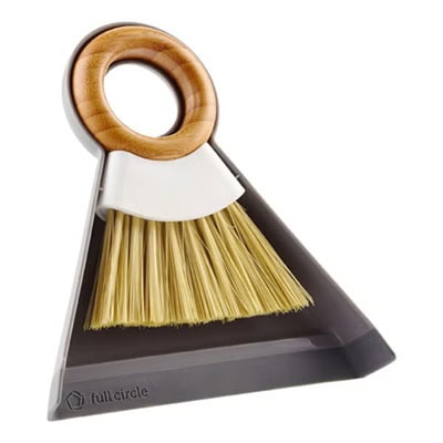 A dustpan and brush set. The brush has a round handle.