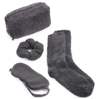 A gray travel set with eye mask, socks, and scrunchie