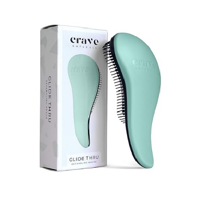 A green detangling brush next to the packaging