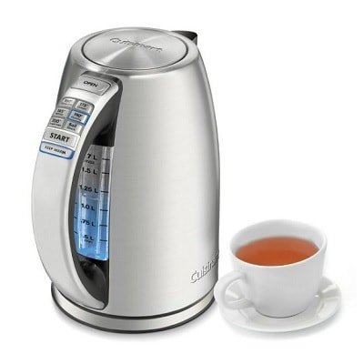 A Cuisinart Perfectemp Electric Kettle next to a white teacup with tea and a saucer