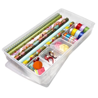 A clear plastic organizer box full of wrapping paper and ribbon