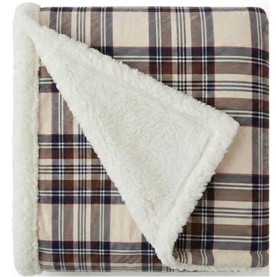 A tan, navy, white, and brown throw blanket with one sherpa side