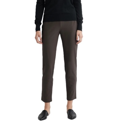 A woman wearing black flats, a black top, and brown ankle pants