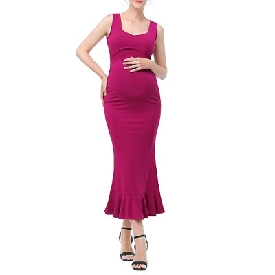 A pregnant woman wearing a long sleeveless pink dress and black sandals