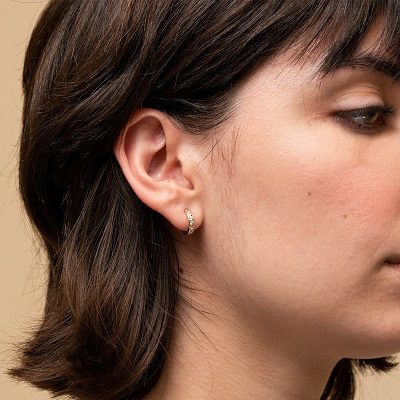 A woman wearing a huggie style earing
