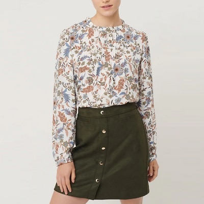 A woman wearing a Floral Pintucked Blouse and a black mini-skirt
