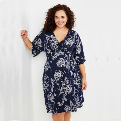 A woman wearing a Flutter-Sleeve Floral Wrap Maternity Dress