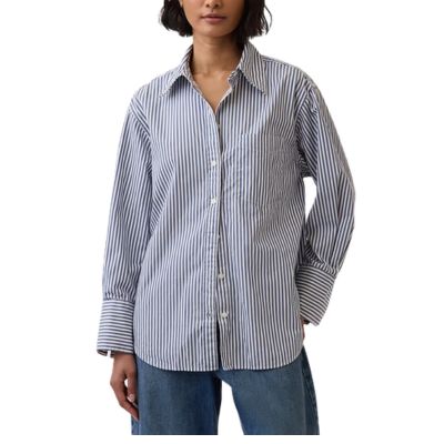 A woman wearing a brown-and-blue striped blouse and blue jeans
