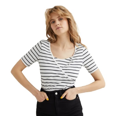 A woman with long blonde hair wearing a black-and-white striped nursing top and black pants (legs cropped out)