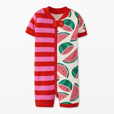 A one-piece baby pajama with half pink-and-red stripes and half watermelon print