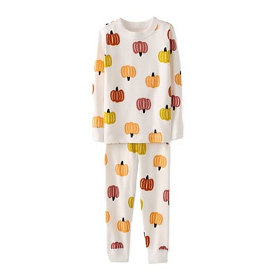 A white pair of kids' pajamas (shirt and pants) with a pumpkin print
