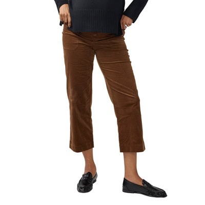 A woman wearing a navy sweater, brown corduroy pants, and black loafers