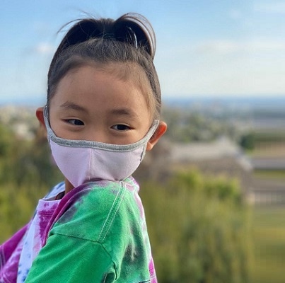 A little girl wearing a face mask