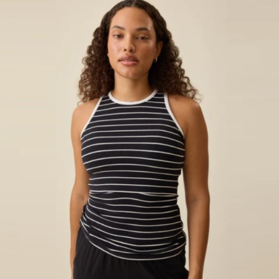 A woman wearing a black-and-white nursing tank and black pants
