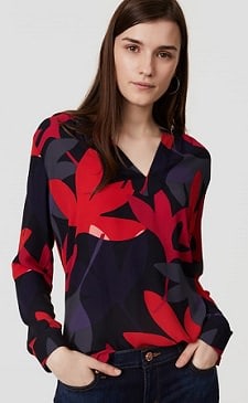 A woman wearing a New Loft black dress red floral ruffle hem long sleeve