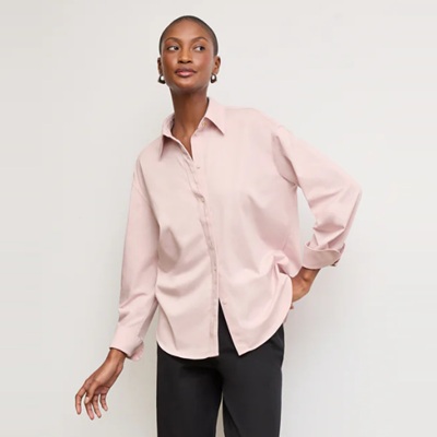 A woman wearing a pink blouse and black pants
