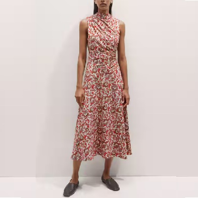 A woman wearing a red floral midi dress and black flats