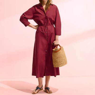 A woman wearing a maroon dress and tan sandals