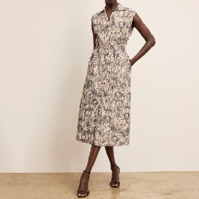 A woman wearing a midi blue/ecru floral dress with sandals