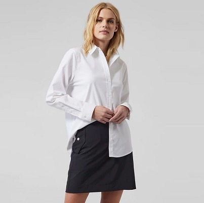 A blonde woman wearing a white button-front shirt and black skirt