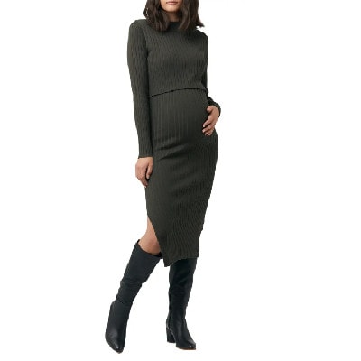 A woman wearing a green maternity dress and black boots