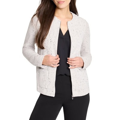 A woman wearing a black top, black pants, and an off-white zip-front jacket