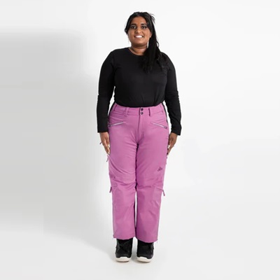 A woman wearing pink snow pants, a black top, and black snow boots