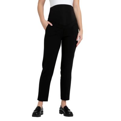 A woman wearing a white top (half of body cropped out), black maternity pants, and black loafers