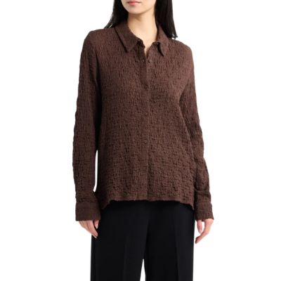 A woman wearing a brown blouse and black pants